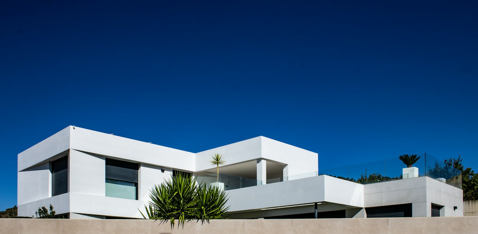 Modern white architecture against a blue sky, used in a property advertising concept